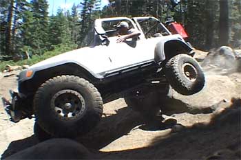 Jeep going over a big rock